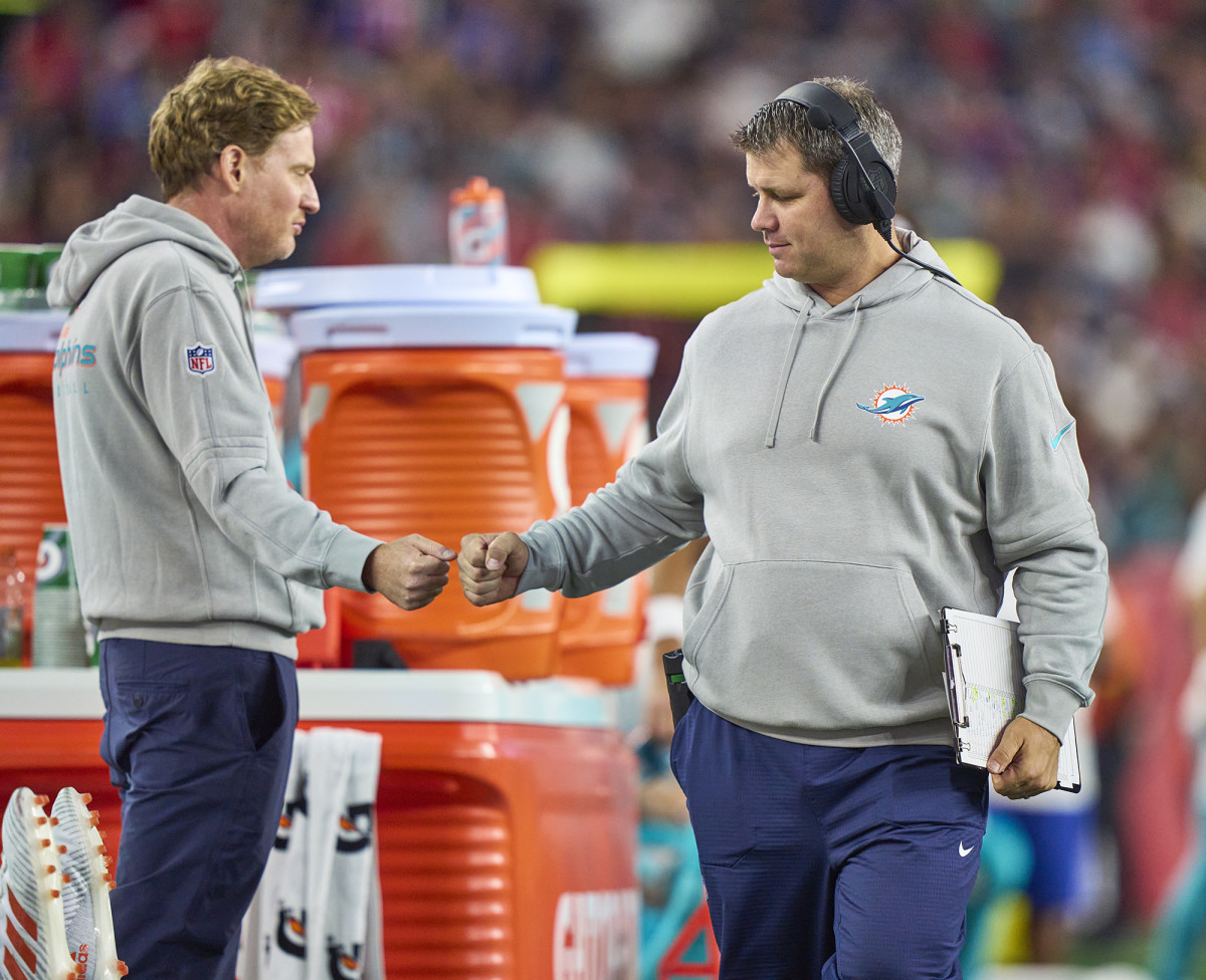 Dolphins video director Mike Nobler (left) gives a fist bump on the sideline during a game.